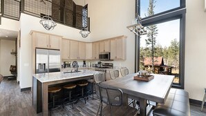 Una cocina moderna con una isla grande, taburetes de bar y vistas al exterior.