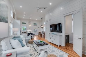 Relax in a spacious living area with a large flat-screen TV, comfortable seating, and a dining table.