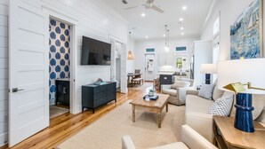A spacious living area with a wooden floor, a dark blue cabinet, a beige sofa, and a coffee table. - BVR 43 - Off The Hook by Liquid Life (Orange Beach)