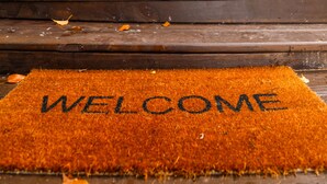 Felpudo con la palabra "WELCOME" frente a una puerta azul.