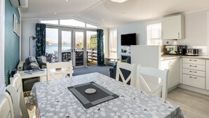A modern kitchen with a flat-screen TV, a microwave, and a coffee maker. - Lake View Lodge (Bedford)
