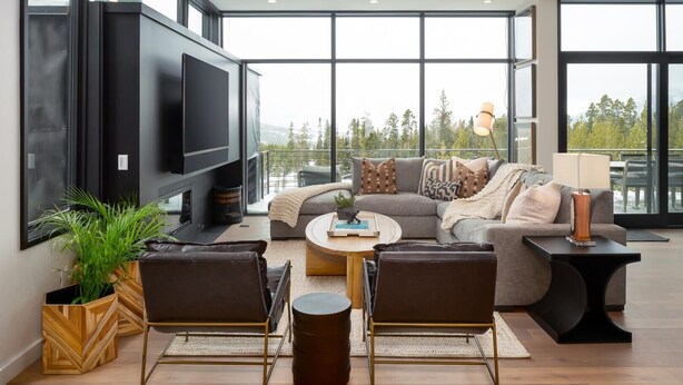 Een moderne woonkamer met een grote flatscreen televisie, een grijze modulaire bank, een salontafel en een open haard.