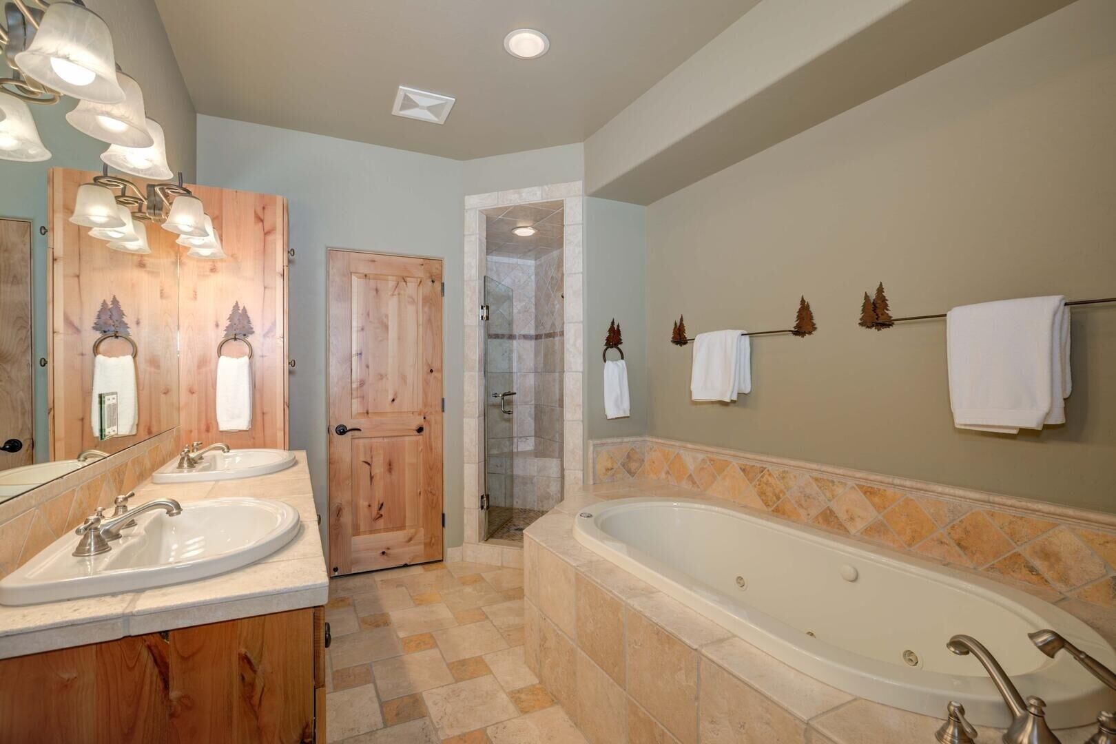 A bathroom with two sinks, a large bathtub, and a shower area.