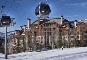 Une station de ski dotée d’un télécabine, de bâtiments en bois et d’un paysage enneigé.