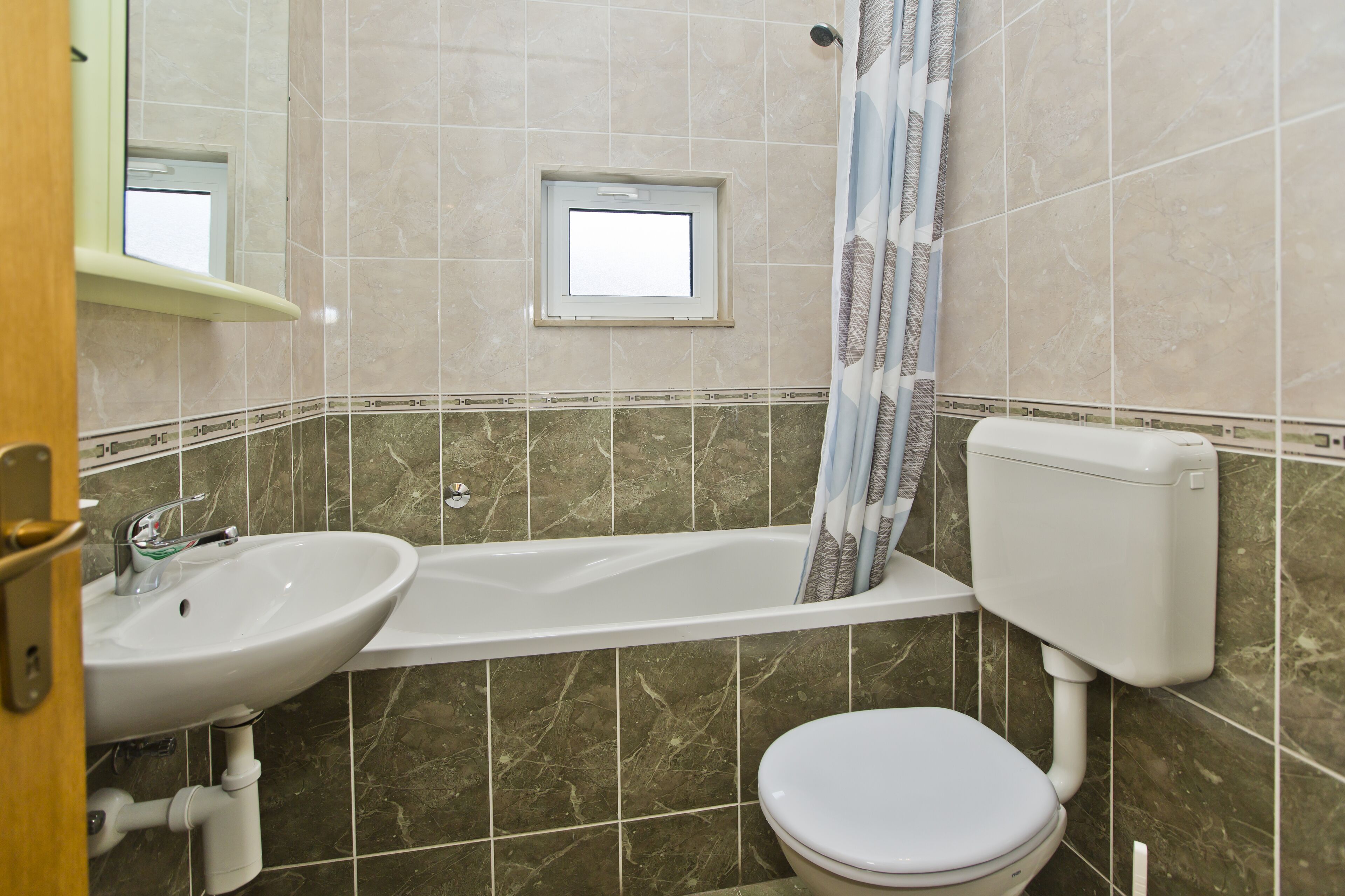 A bathroom with a sink, toilet, and bathtub.