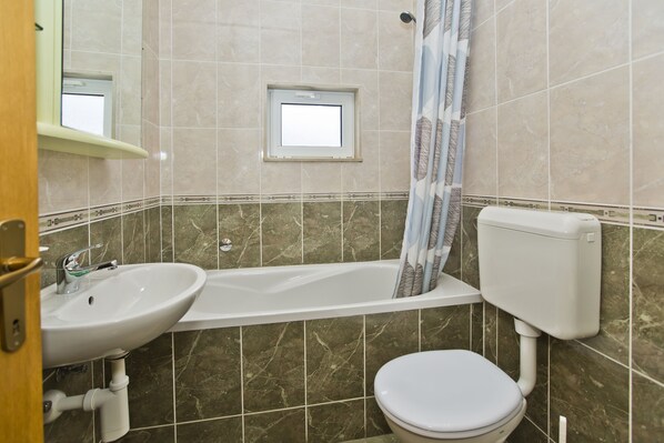 A bathroom with a sink, toilet, and bathtub. - Apartmani Kresic 1 (Hvar)