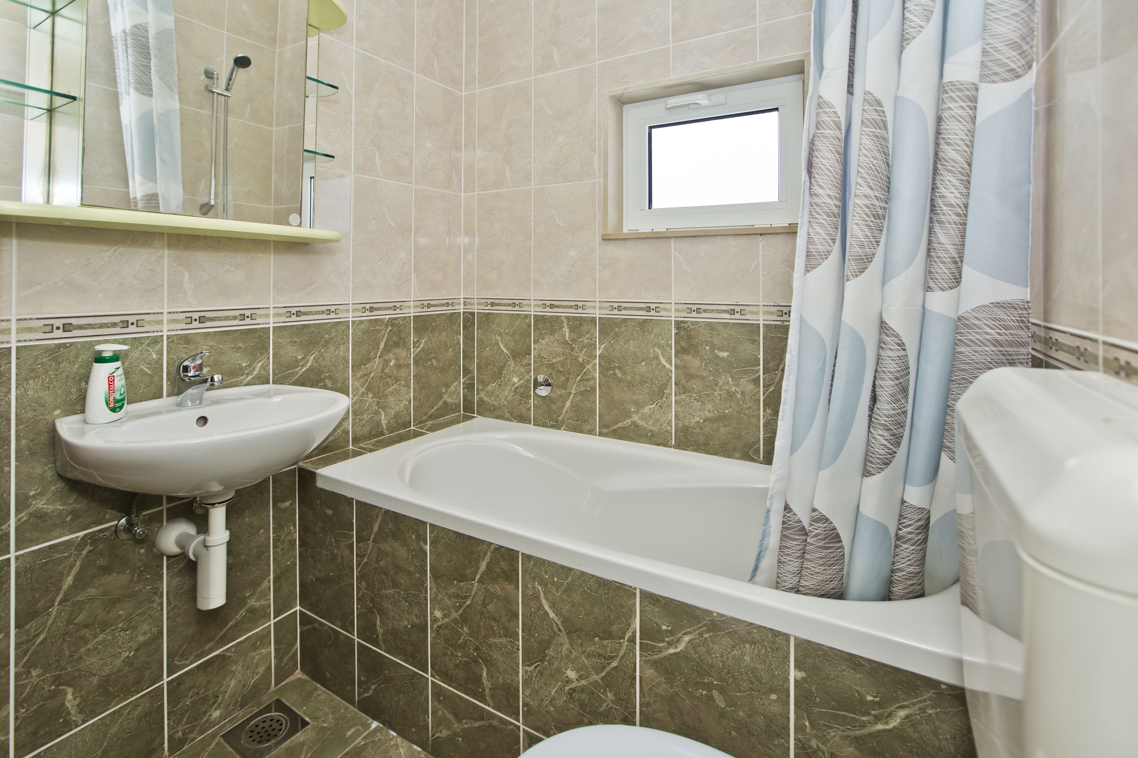 A bathroom with a sink, bathtub, and shower.