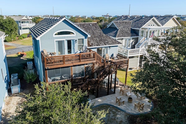 A coastal vacation home with a wooden deck, outdoor seating, and a view of the ocean. - Island Time: Golf Community, Beach Club Access w/ Pool and Oceanfront Parking (Nags Head)