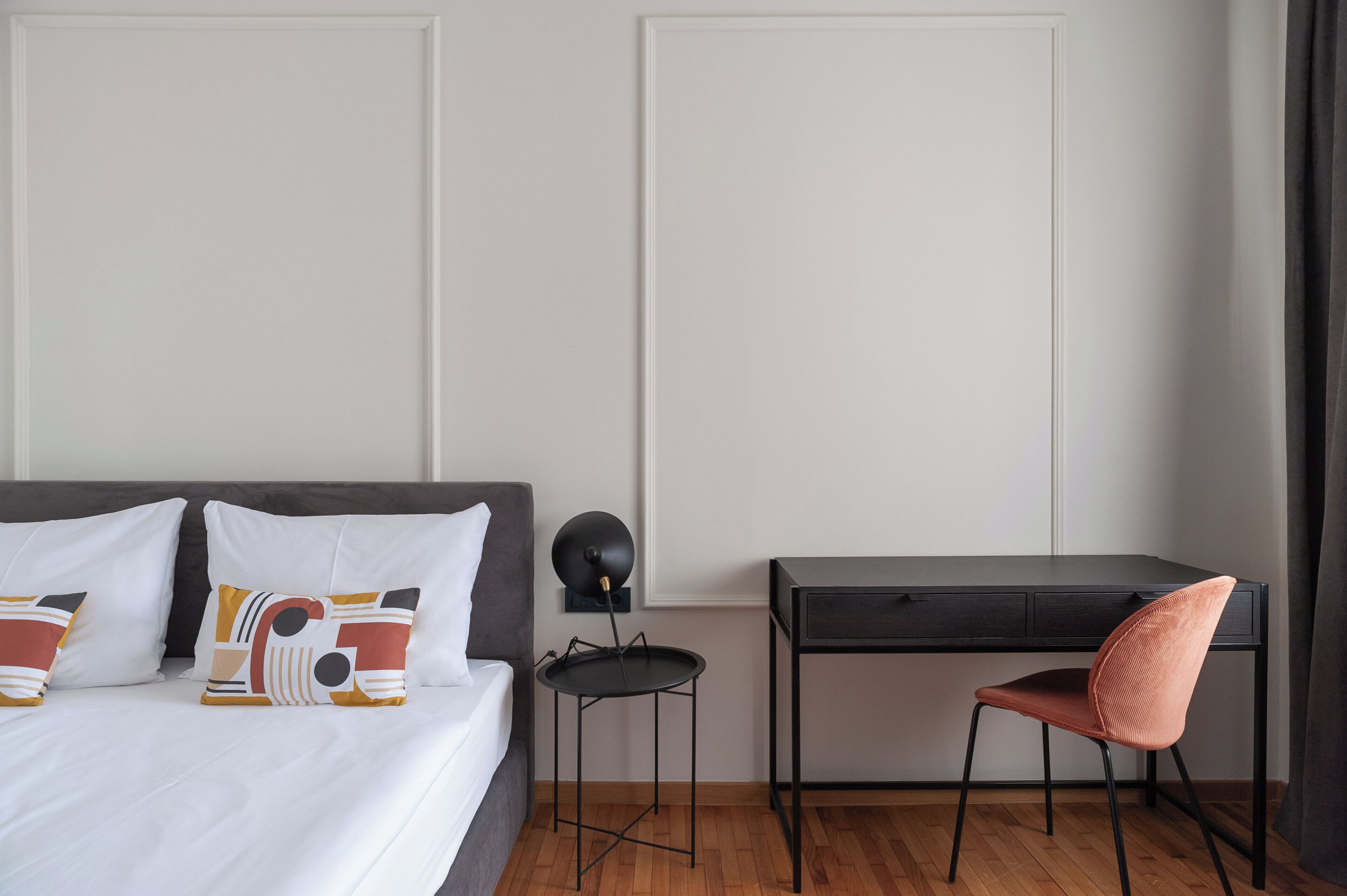 A bedroom with a bed, a desk, and a chair.
