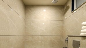 Een moderne badkamer met toilet, douche en wastafel.