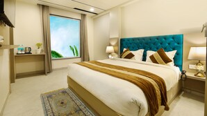 Een hotelkamer met een groot bed, een raam met gordijnen, een nachtkastje met lamp en een plafondventilator.