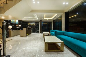 Experience the luxurious lobby with a sleek reception desk, plush seating area, and marble floor.