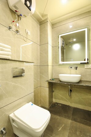 Bathroom features a toilet, sink, and mirror with integrated lighting.