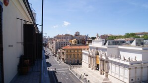 Une rue de la ville, avec des immeubles, un ciel dégagé et une statue.