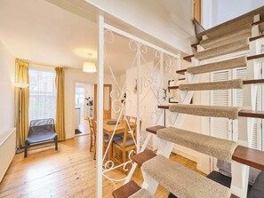 A staircase with a cat tree, wooden flooring, and a dining area with chairs and a table. - Host & Stay | Saint Peters (Canterbury)