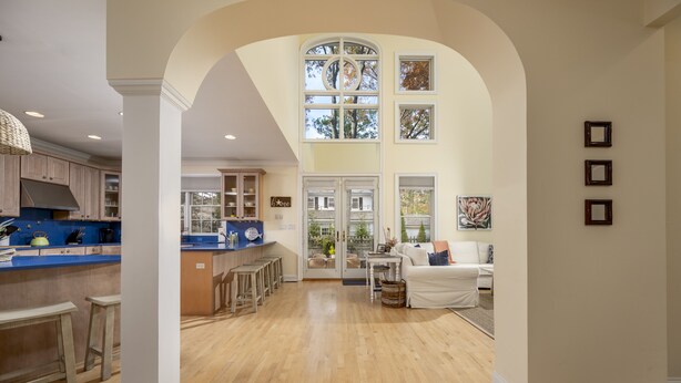 A spacious kitchen with wooden cabinets, a blue countertop, and a large window overlooking a garden.