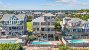 Un hôtel en bord de mer, composé de plusieurs bâtiments à étages, doté de piscines extérieures et offrant une vue sur la plage.