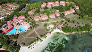 An aerial view of a resort with multiple buildings, a swimming pool, and a beach area. - Studio vue mer Gwada ds Village Vacances Ste Anne (Sainte-Anne)