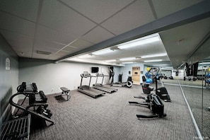 A gym with treadmills, weight machines, and exercise balls.