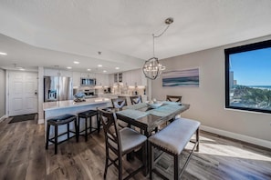 A modern kitchen with a central island, stainless steel appliances, and a dining area with a view.