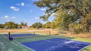 A tennis court with a net, surrounded by trees and a fence. - Little Dutch Cabin 101-12 Min to Magnolia-baylor (Waco)