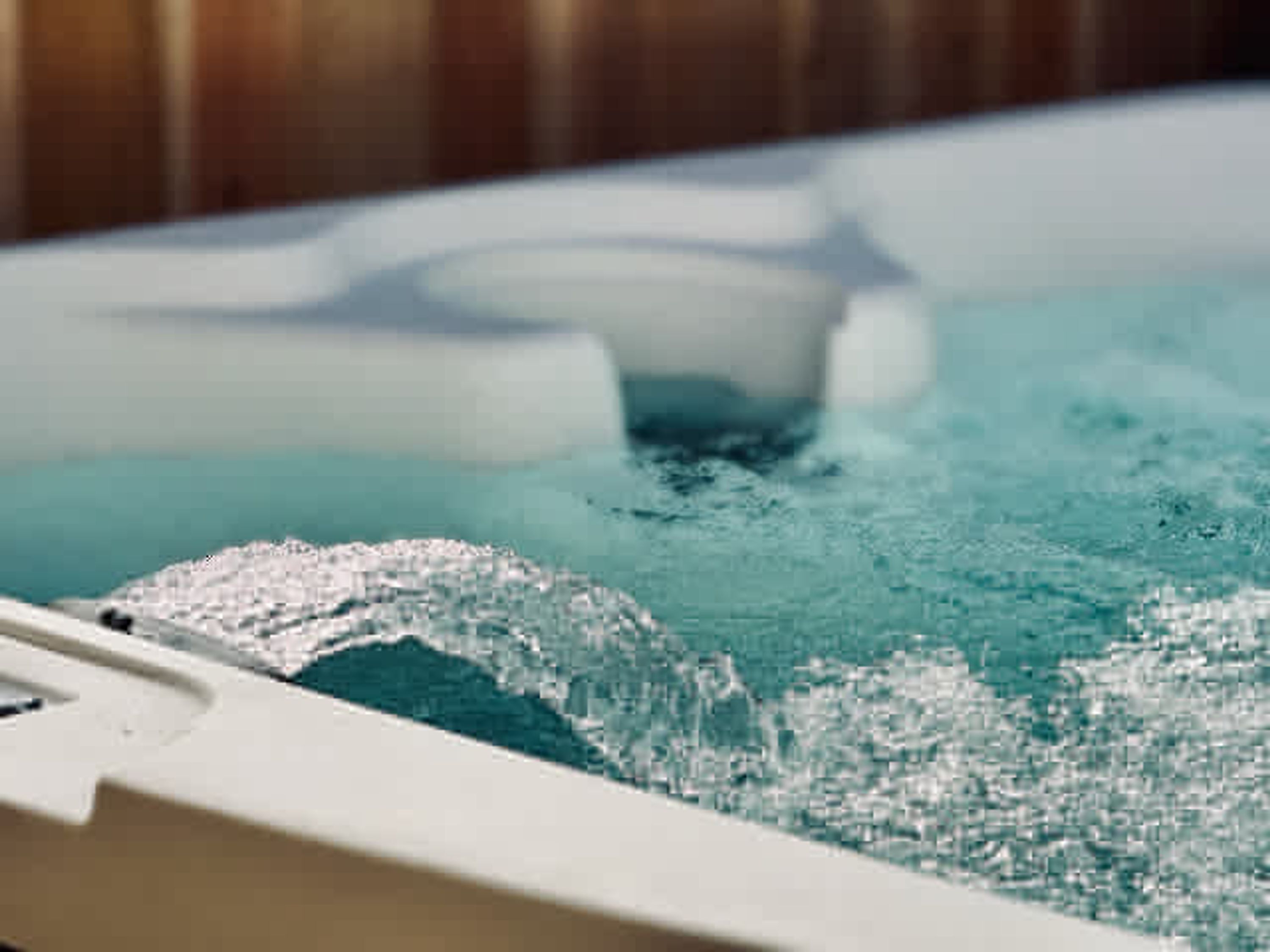 A hot tub with clear water and visible bubbles, indicating active use.
