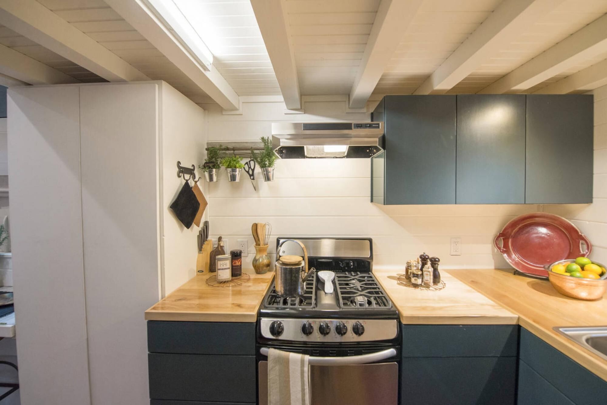 A kitchen with a stove, oven, and a wooden countertop.