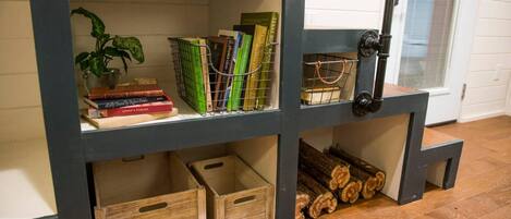 Una estantería con libros, una planta y cajas de madera.