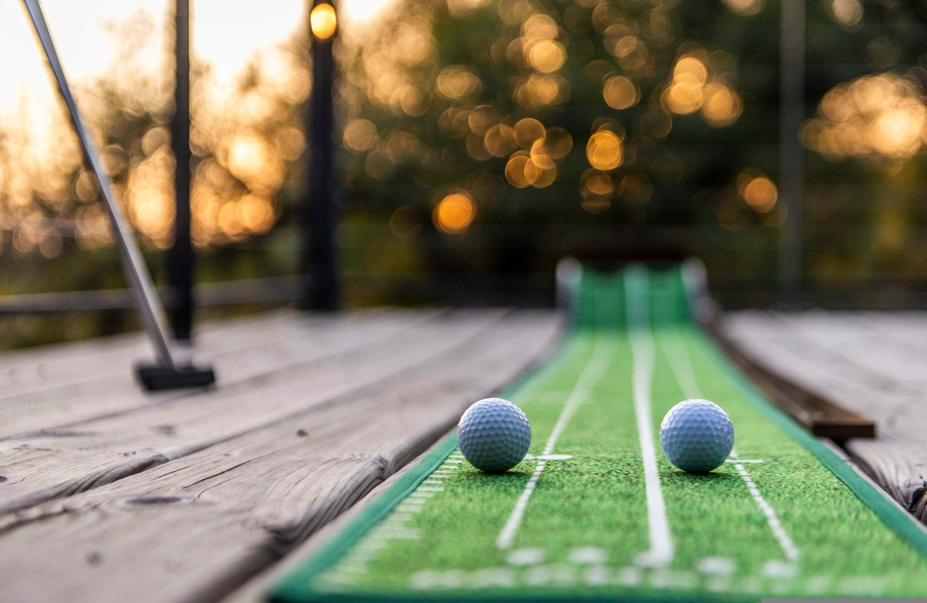 A miniature golf course with two golf balls on the putting green.