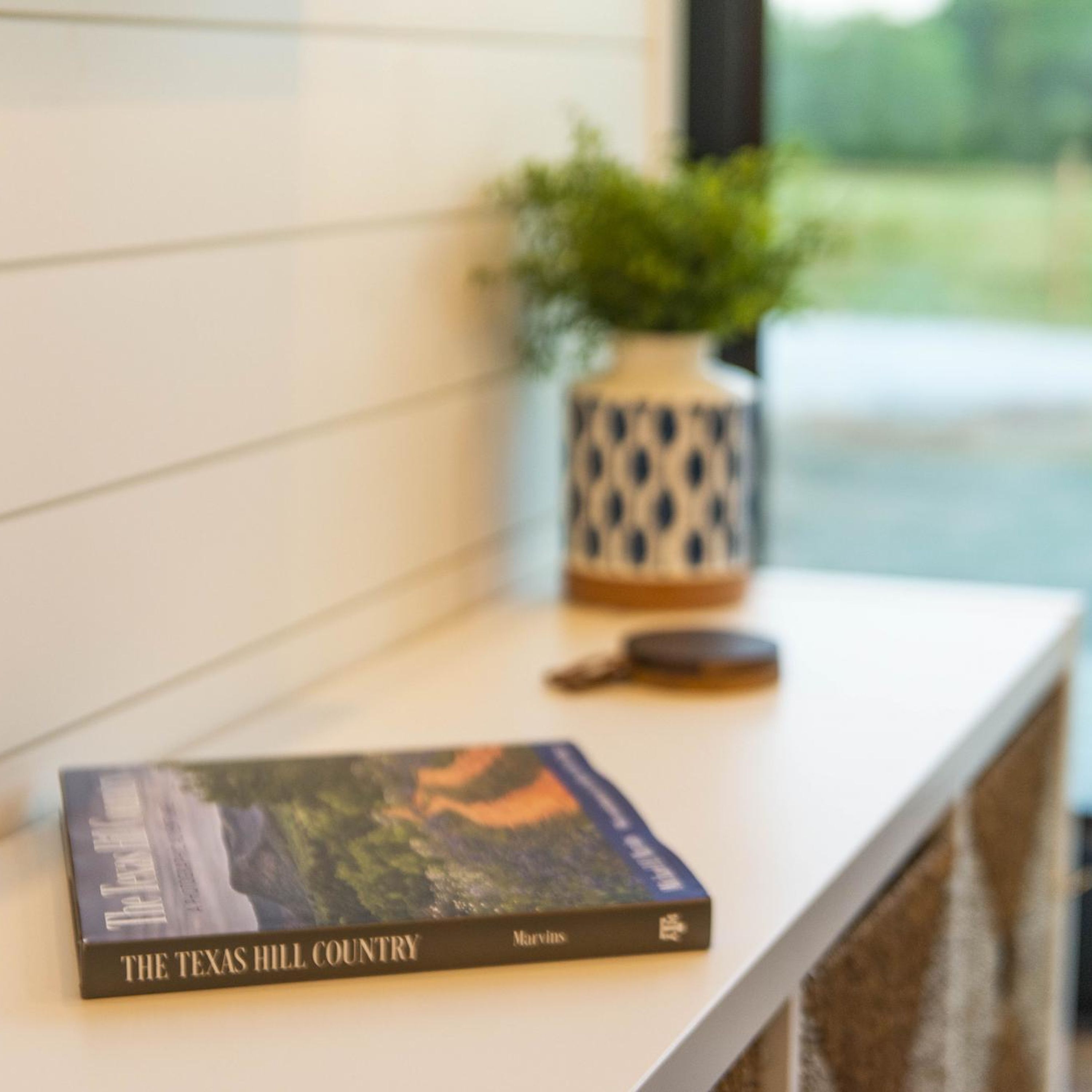 A book titled "The Texas Hill Country" on a white shelf.