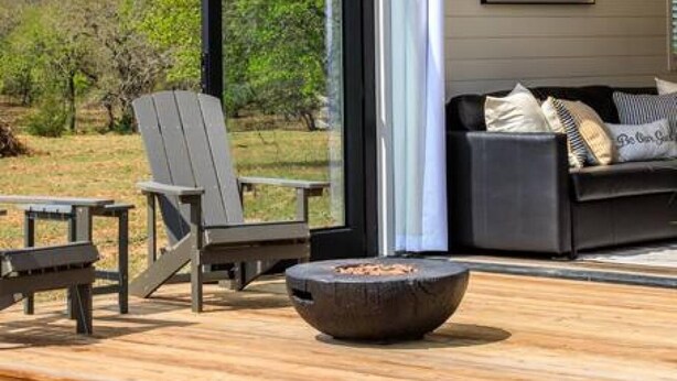 An open deck with a fire pit, outdoor seating, and a view of the surrounding landscape. - New The Yellow Beacon-luxury Shipping Container (Fredericksburg)