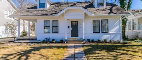 A two-story house with a front porch, a dark front door, and a small attached garage.