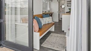 Un intérieur moderne avec une porte-fenêtre coulissante donnant sur un espace de vie comprenant un canapé et une table basse.