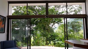 Une chambre moderne dotée d’une grande porte-fenêtre coulissante donnant sur un jardin.