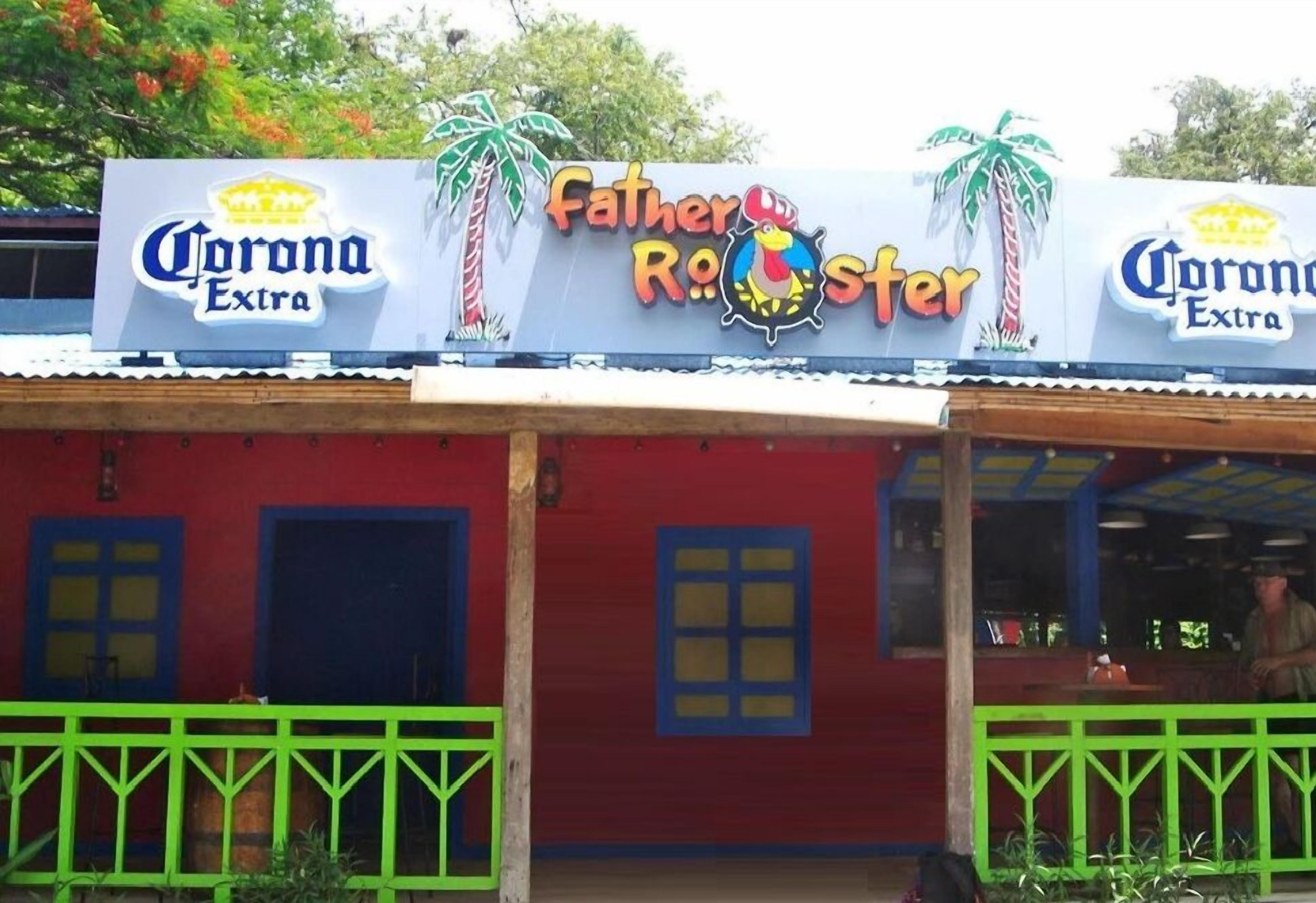 Ein Gebäude mit einem Schild, auf dem die Logos 'Father Rooster' und 'Corona Extra' zu sehen sind.