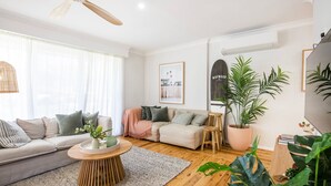 A modern living room with a sofa, coffee table, and potted plants.