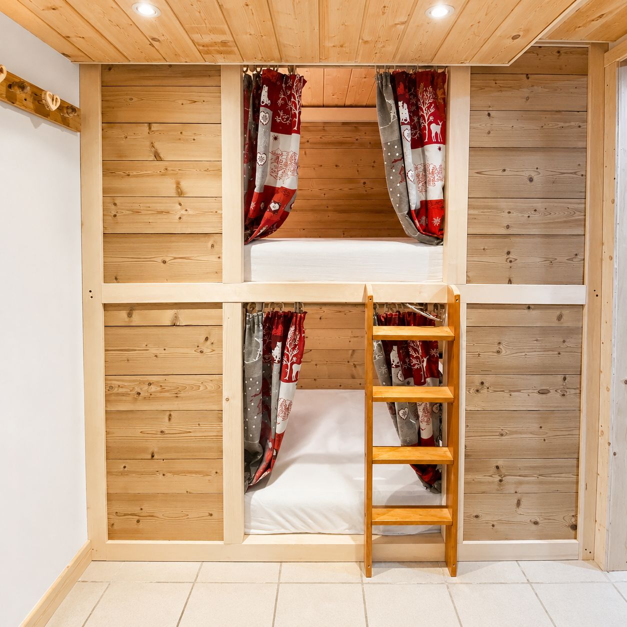 Una stanza con un letto a castello, pareti in legno e una scala.