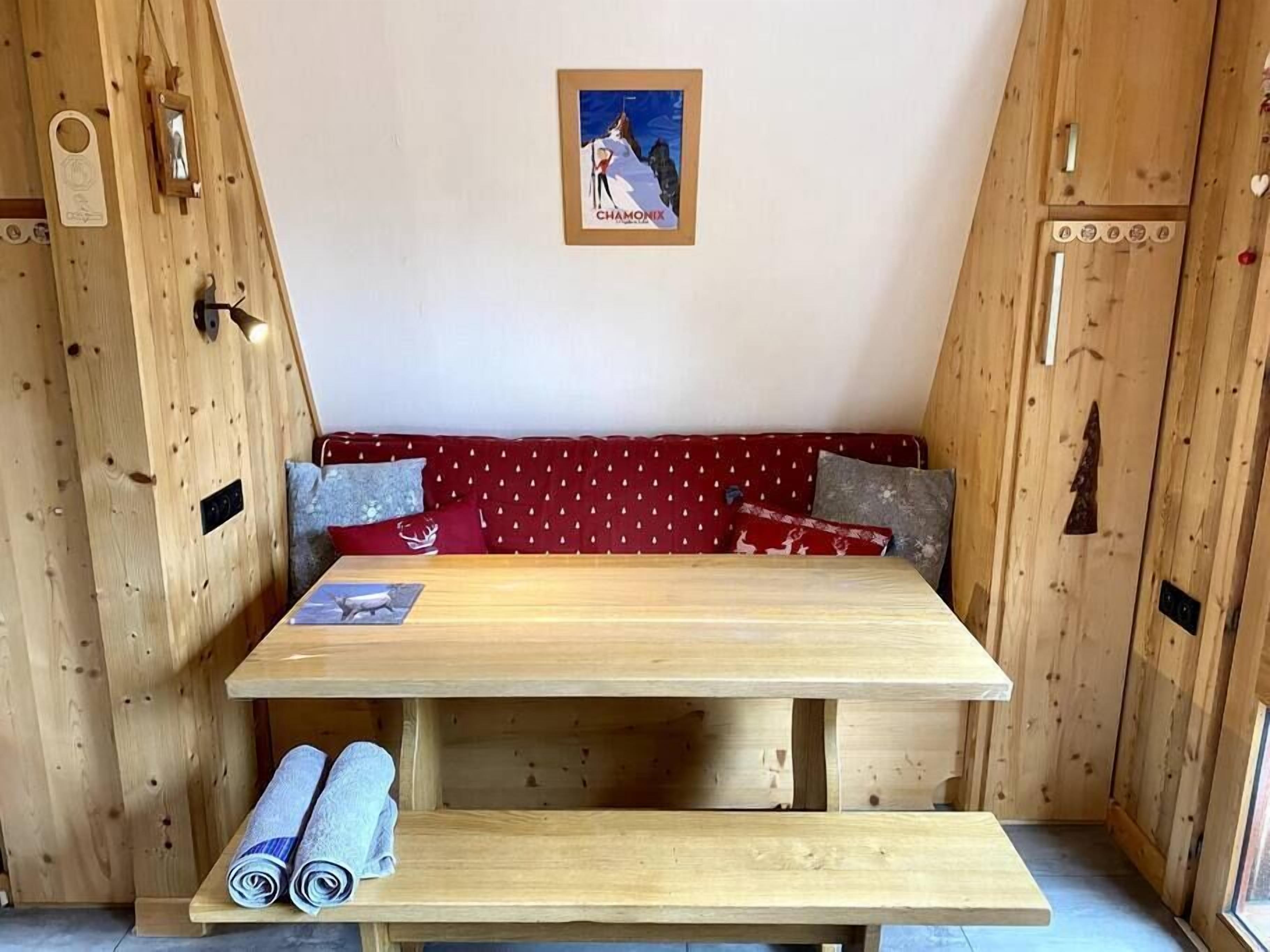 A wooden cabin with a bench, a table, and a poster on the wall.