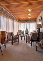 Un salón amplio con techo de madera, una batería y un gran jarrón decorativo.