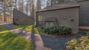 A modern two-story house with a sloped roof, a covered porch, and a well-maintained lawn. - Perfect Location, Near Golf Course, SHARC passes (Sunriver)