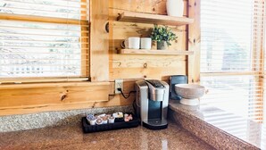 Een keuken met houten planken, een koffiezetapparaat en een kom.
