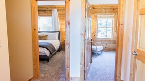Een slaapkamer met een bed, nachtkastje en raam.