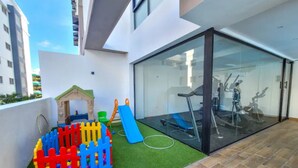 Un edificio moderno con una porta in vetro che dà accesso a una palestra.
