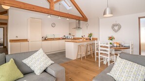 Une cuisine moderne avec des poutres en bois, un îlot central et des tabourets de bar.