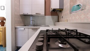 Eine moderne Küche mit einem Gasherd, einer Spüle und einem kleinen Fenster.