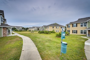 A row of townhouses with a grassy lawn and a sidewalk. - PCB Condo w/ Pool Access: 1 Mi to Beach! (Panama City Beach)