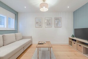 Basic-Apartment, Mehrere Betten | Wohnbereich | Fernseher