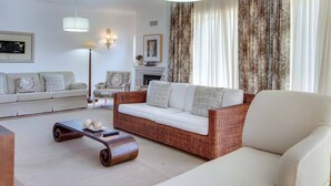 A living room with a sofa, a coffee table, a fireplace, and curtains. - Villa Costa Rica - Four Bedroom Villa, Sleeps 8 (Algarve)