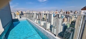 A rooftop pool with a city view, surrounded by high-rise buildings.