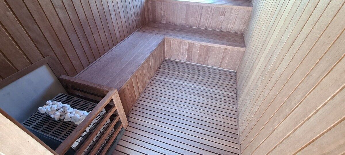 Una sauna de madera con bancos y suelo inclinado.